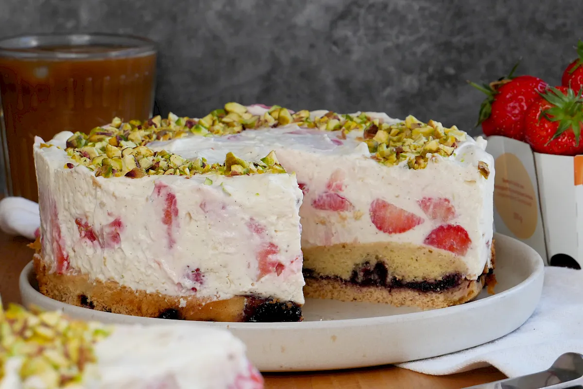Eine Kuchen besteht aus zwei verschiedenen Kuchenböden mit einer Marmeladenschicht dazwischen und einer fruchtigen Mascarpone-Erdbeer-Creme.