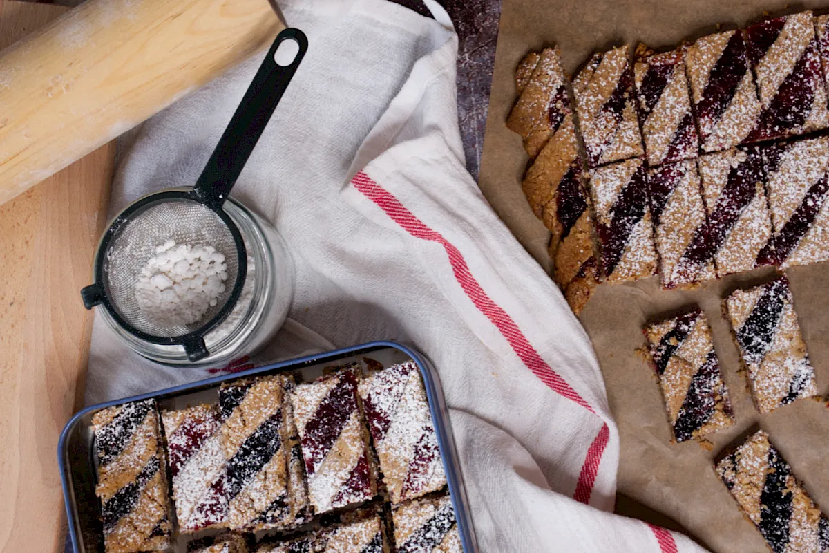 Linzer-Weihnachtskekse: Ein zarter Mürbeteig mit Mandeln, bestrichen mit fruchtiger Marmelade und verziert mit einem Teiggitter – goldbraun gebacken und himmlisch lecker!